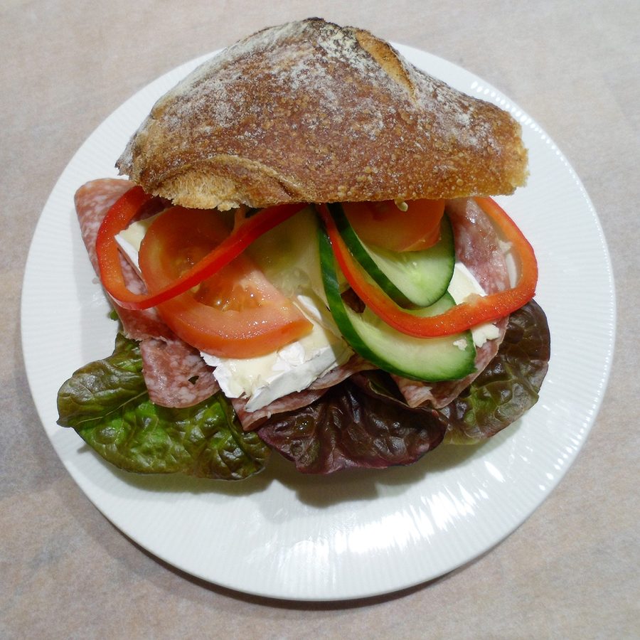 Smörgås på fat med sallad, tomat, gurka, paprika och pålägg